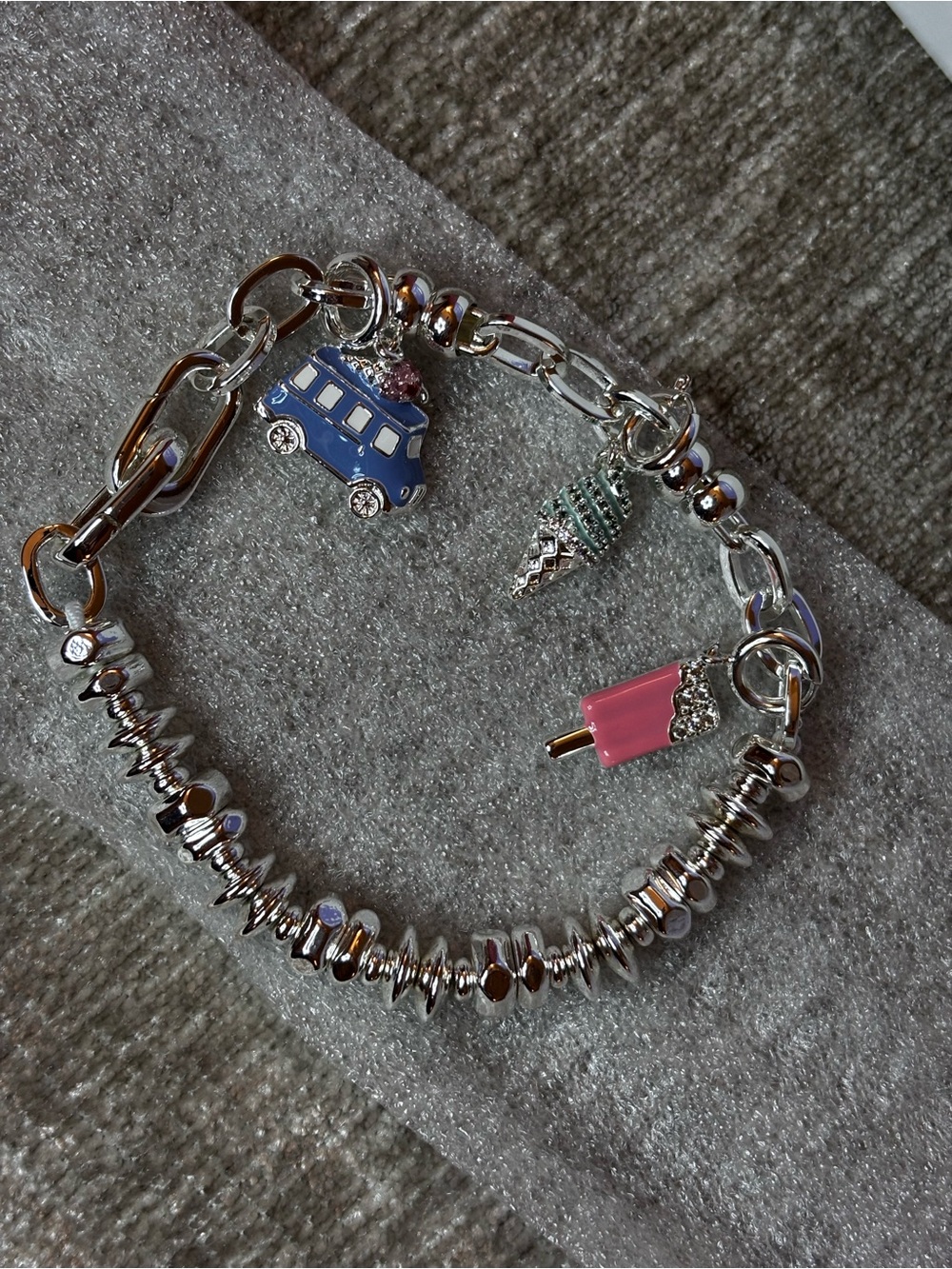 Silver plated charm bracelet with three removable charms.